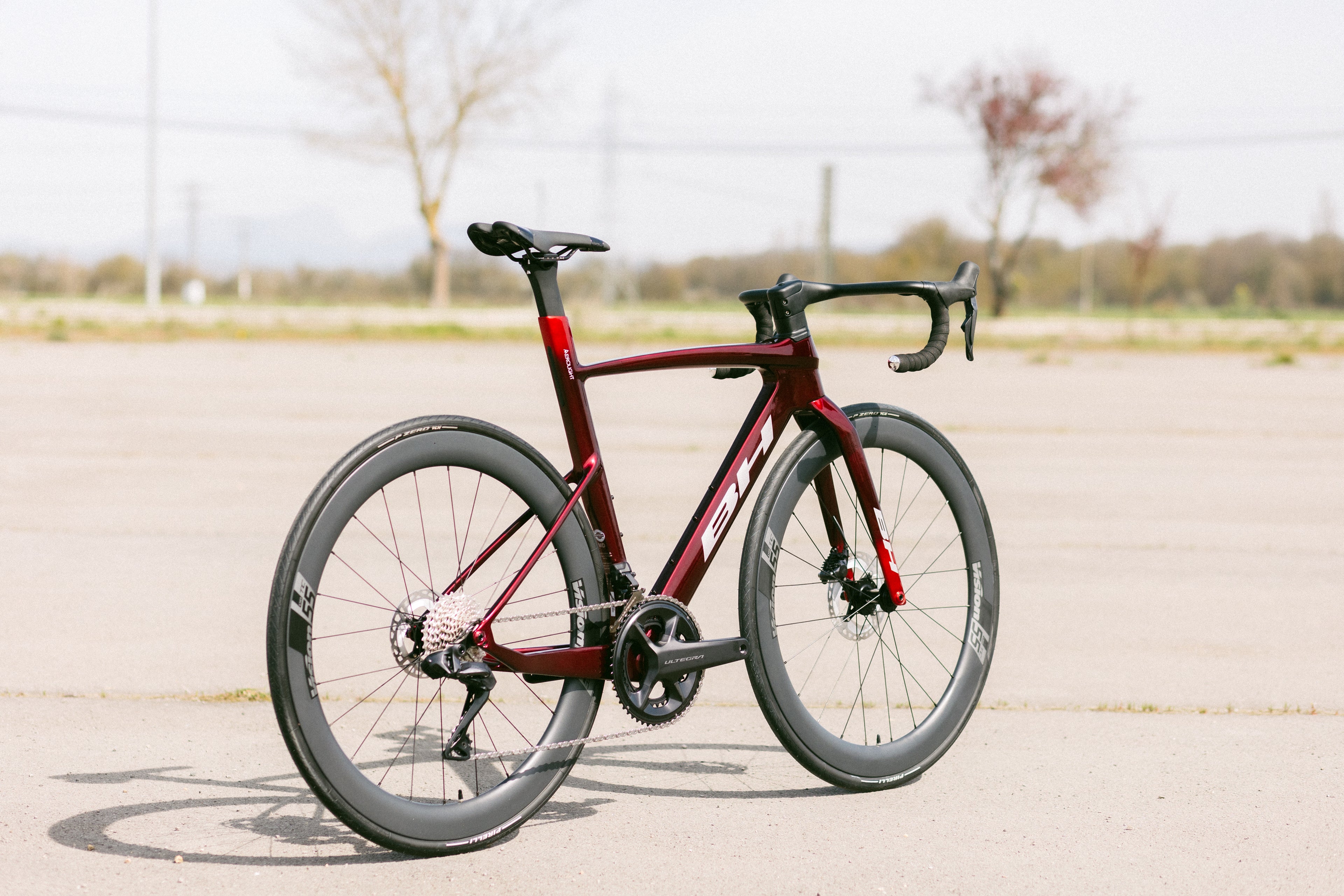 Vélo de route BH Aerolight rouge, cadre aérodynamique, vue 3/4 côté transmission, roues profil haut, freins à disque, vélo aéro perf., pour course pro